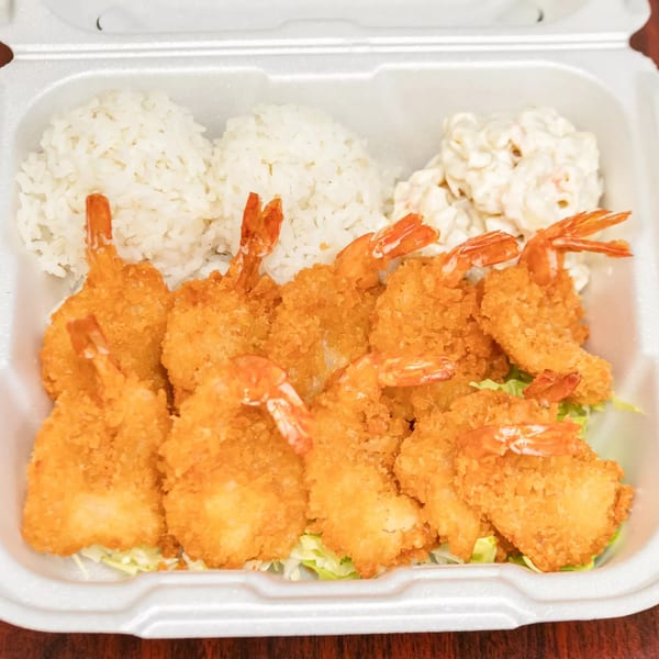 F's Hawaiian Food's fried shrimp plate with rice and macaroni salad in a takeout container.